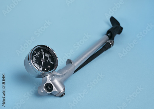 hand operated high pressure air pump for air shocks and forks with manometer isolated on blue background