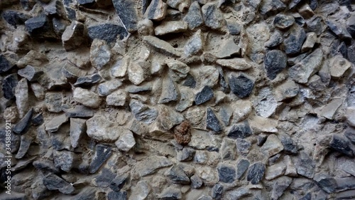 Old gray small stones on the wall