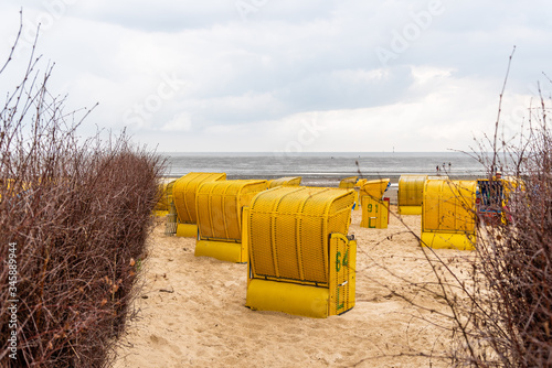 Sandy beach and typical hooded beach chairs in Cuxhaven in the North Sea coast a cloudy day of Summer. Germany