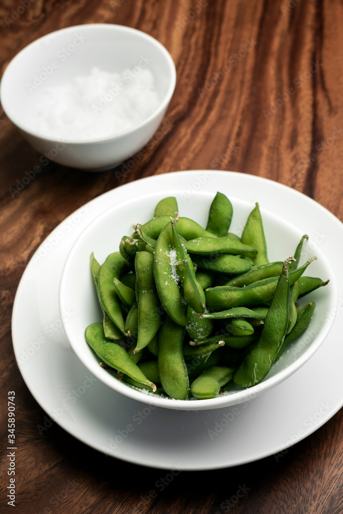 edamame beans in bowl on table with sea salt edamame beans in bowl on table with sea salt