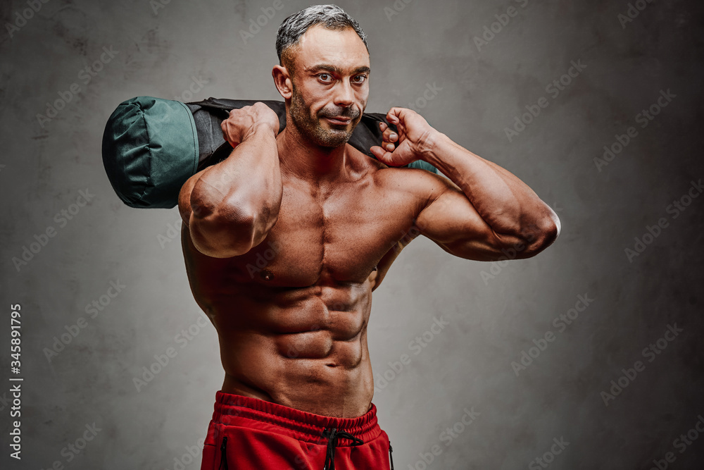 Healthy and energetic man doing lifting exercises, focused and looking strong