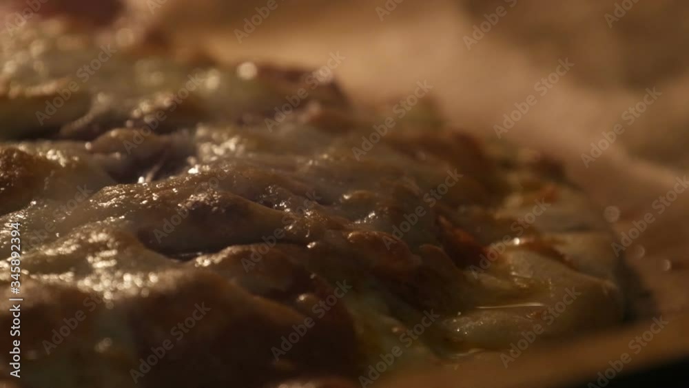 Close up of big pizza is baked in the oven. Cheese melts on pizza surface Close up of big pizza is baked in the oven. Cheese melts on pizza surface