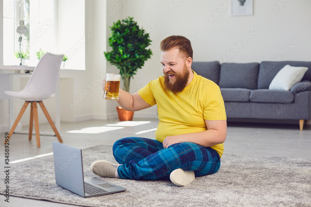 Online conference video call chat. Online party with friends. Funny man holds a glass with beer, communicates with friends video chat call online at home.