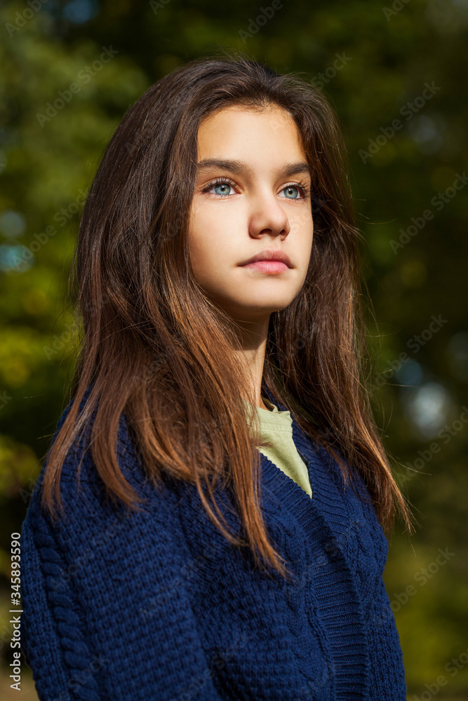 Pretty brunette little girl posing in autumn park background Pretty brunette little girl posing in autumn park background