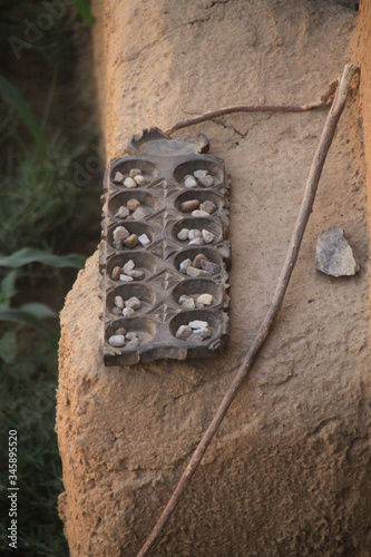 stara afrykańska gra mankala leżąca na kamieniu w plenerze