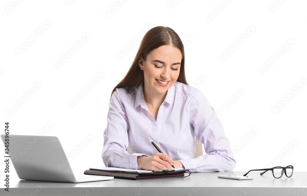 Beautiful young secretary at table on white background Beautiful young secretary at table on white background