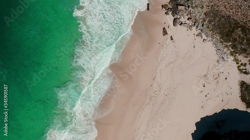 Cinematic bird eye view of a beach at Cape of Good Hope in South Africa on a sunny day with beautiful turquoise water.