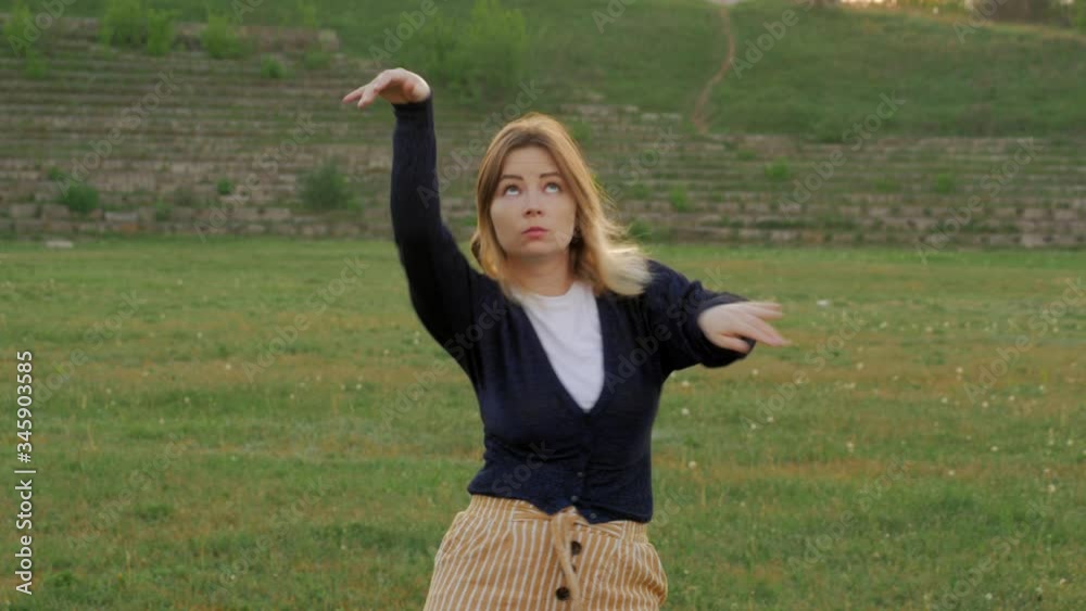 happy young woman dancing in the summer park happy young woman dancing in the summer park