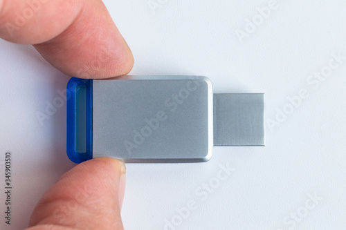 USB Flash White background. There is a metal flash on it. Close-up. The cap is missing photo