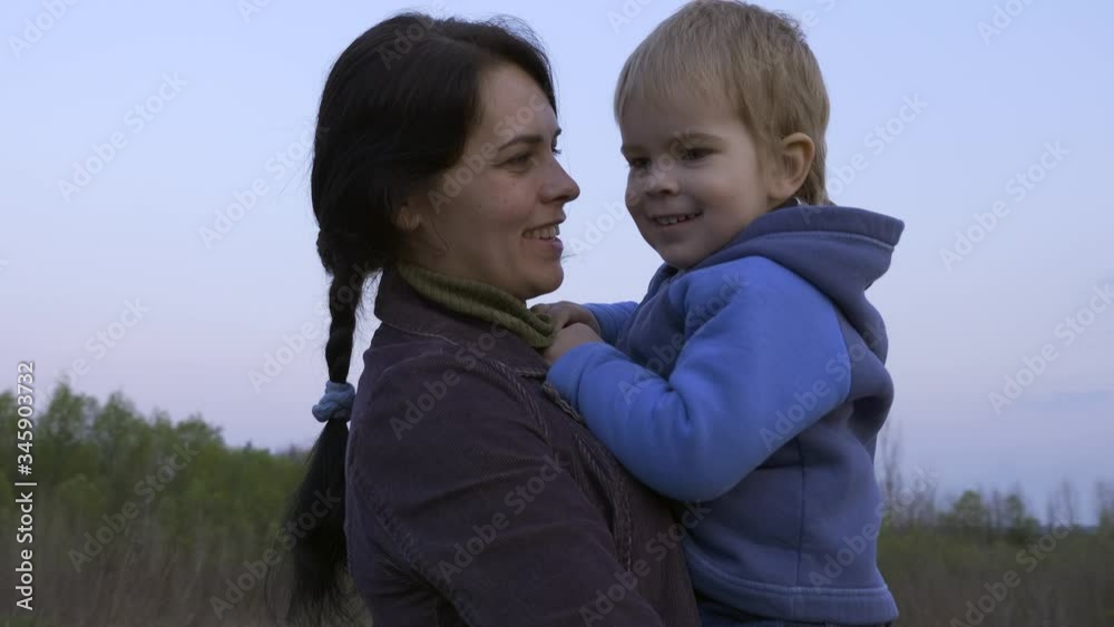 Portrait Beautiful Loving Mother Holds Hugging Cute Little Son. Spring Evening Portrait Beautiful Loving Mother Holds Hugging Cute Little Son. Spring Evening