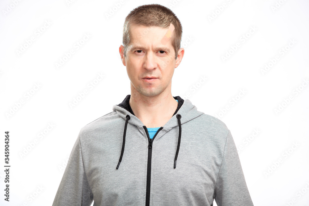 Sporting a confident wounded man with a Band-Aid on his head from the injury, sportswear, smiling, looking at the camera. Isolated Sporting a confident wounded man with a Band-Aid on his head from the injury, sportswear, smiling, looking at the camera. Isolated