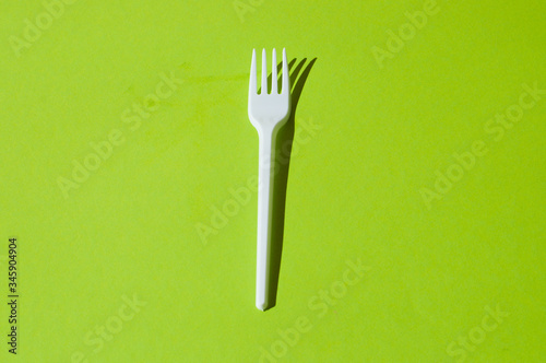 White plastic fork on a green background