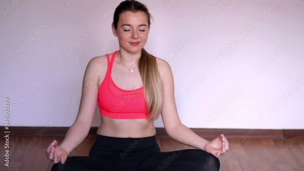 Young athletic woman meditating, zen yoga practice at home Young athletic woman meditating, zen yoga practice at home