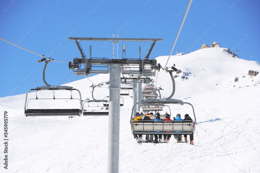 Chairlift view with skiers going up to the mountain in ski valley Courchevel, France. Chairlift view with skiers going up to the mountain in ski valley Courchevel, France.