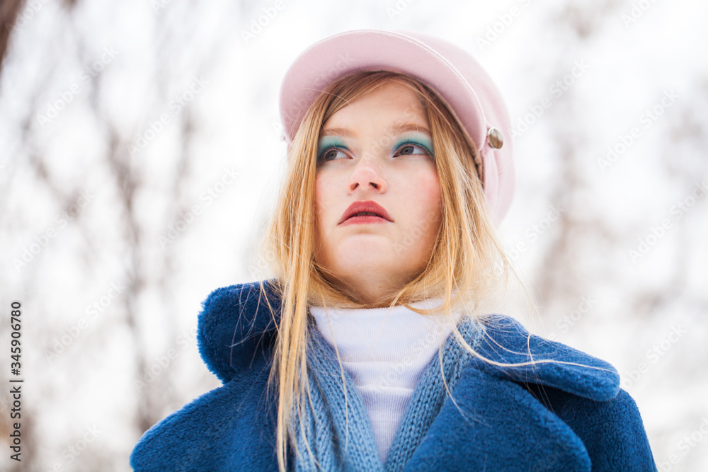 Portrait of a young beautiful blonde girl in a blue coat Portrait of a young beautiful blonde girl in a blue coat