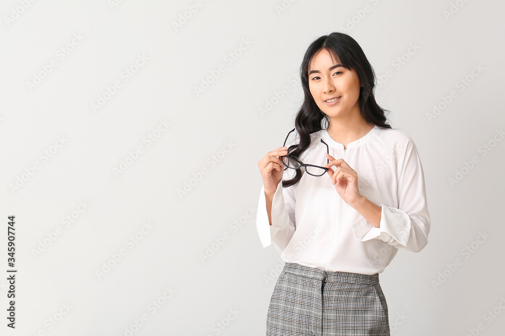 Beautiful Asian secretary on light background Beautiful Asian secretary on light background