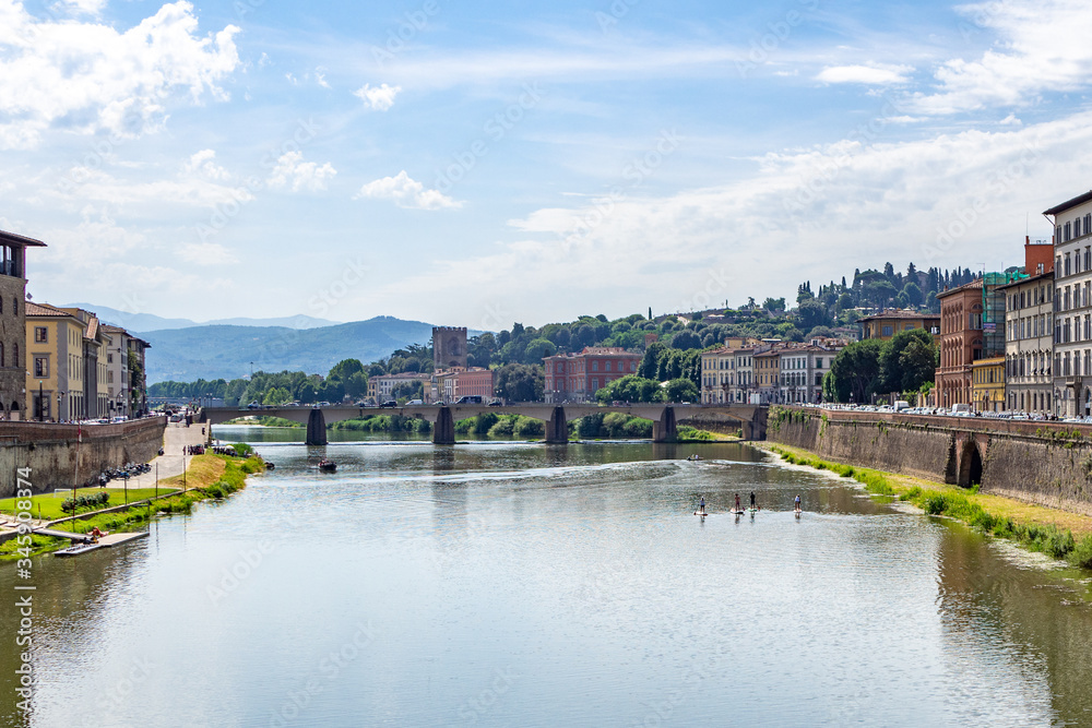 Nice view of Arno river in Florence Italy with SUP surfing people