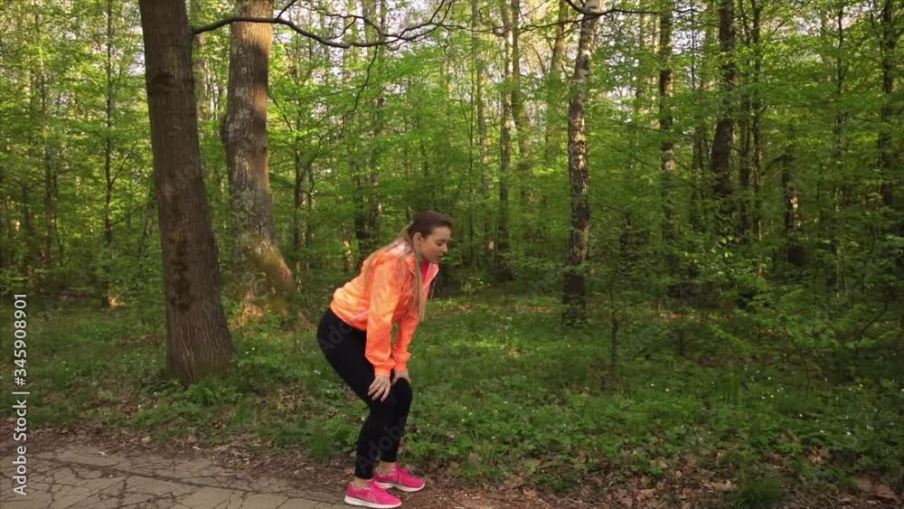 Tired woman stopping after run in park. Exhausted runner have break Tired woman stopping after run in park. Exhausted runner have break