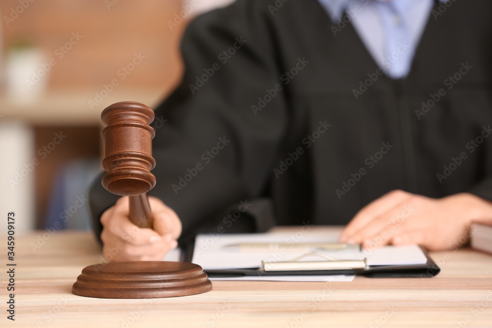 Female judge with gavel at table in office, closeup Female judge with gavel at table in office, closeup