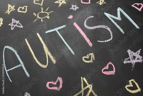 high angle view of chalkboard with autism inscription, hearts, stars and suns