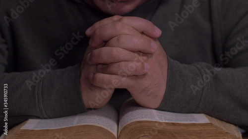 Close Up of Man Praying over the Bible 
