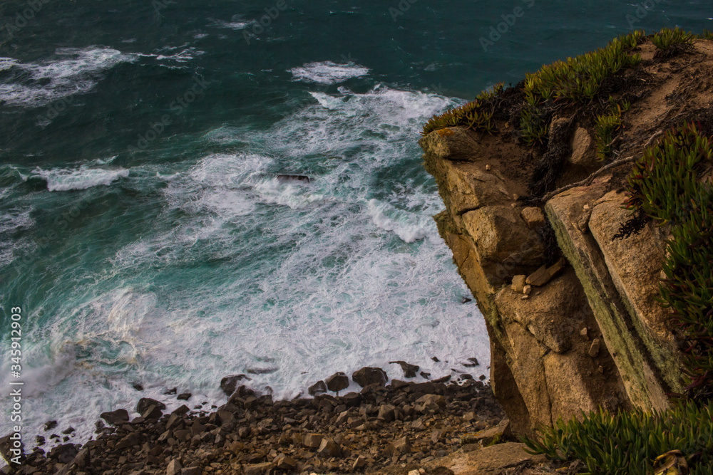 waves crashing on rocks, cliffs Cape Rock at sunset