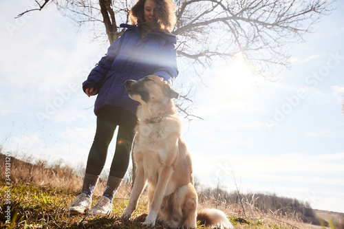 A girl walking with her dog in the country in spring during isolation