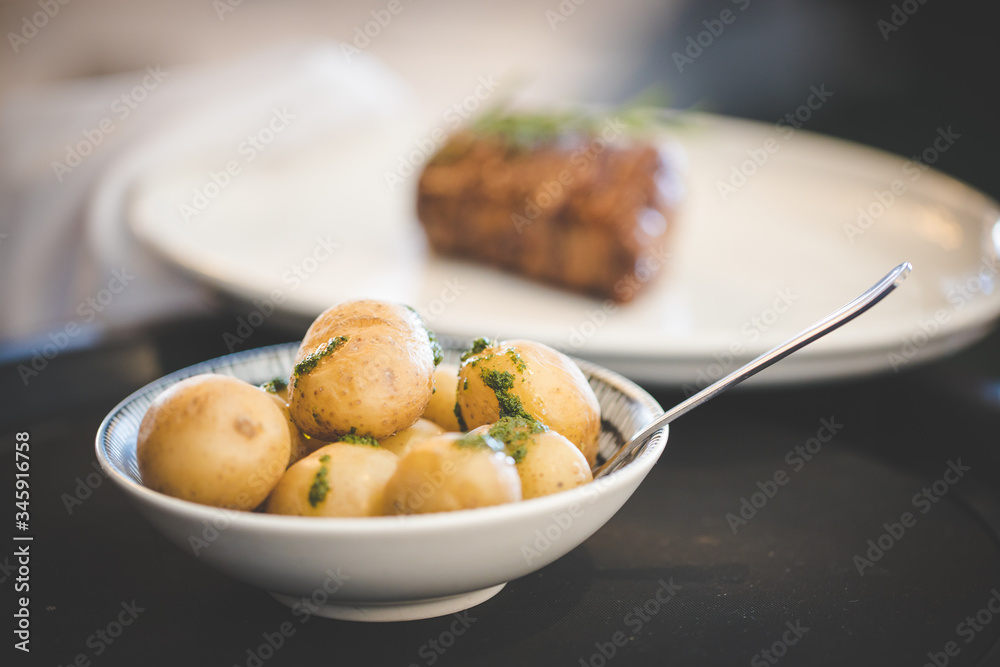 Close up images of a side of boiled potatoes being served in a gourmet restaurant