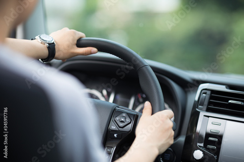 People hands holding steering wheel while driving car on city road © lzf