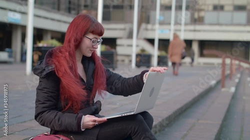 Slow motion shot of student / young professionsl workng outside on her laptop photo