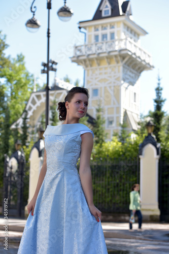 Beautiful brunette in pale blue evening dress outdoor. photo