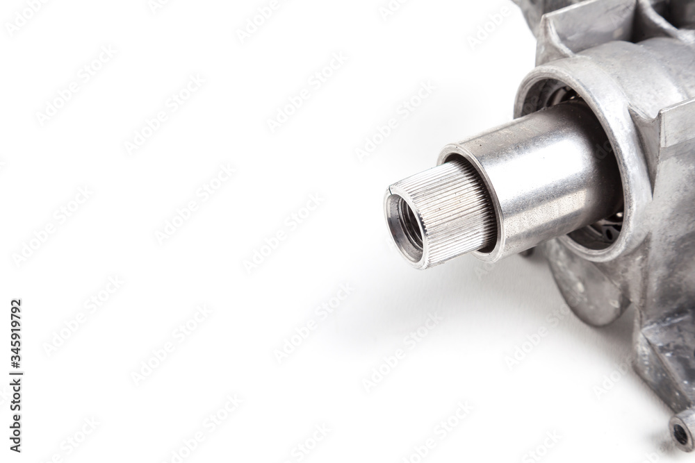 Metal gear shaft with on a cylindrical shape converts the torque into the number of revolutions of the drive wheel close-up on an isolated white background in a photo studio when replacing in service. Metal gear shaft with on a cylindrical shape converts the torque into the number of revolutions of the drive wheel close-up on an isolated white background in a photo studio when replacing in service.