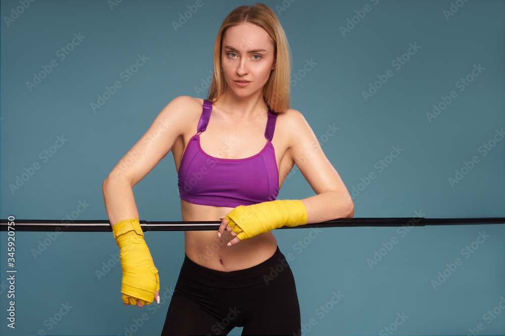 F Female boxer training athlete in boxing bandages on a blue background F Female boxer training athlete in boxing bandages on a blue background