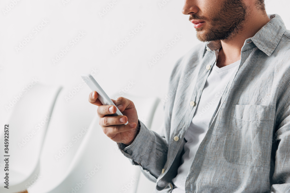 Cropped view of employee using smartphone in office Cropped view of employee using smartphone in office