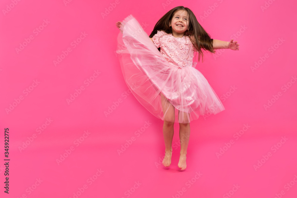 Cute little girl dreams of becoming a ballerina. Little Dancing Girl. Studio Shoot Over Pink Background Cute little girl dreams of becoming a ballerina. Little Dancing Girl. Studio Shoot Over Pink Background