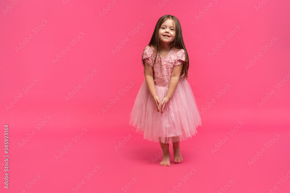 Cute little girl dreams of becoming a ballerina. Little Dancing Girl. Studio Shoot Over Pink Background Cute little girl dreams of becoming a ballerina. Little Dancing Girl. Studio Shoot Over Pink Background
