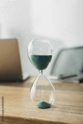 Close up view of hourglass on wooden table in office