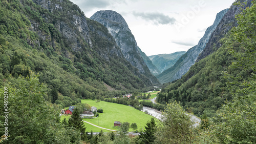 Norwvegian village with traditional wooden red houses in the green valley surrounded by mountain range landscape  Norway