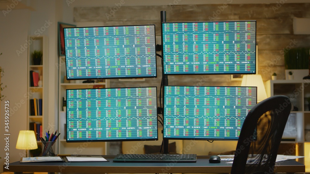 Fototapeta premium Four displays presenting financial data of stock market in broker home