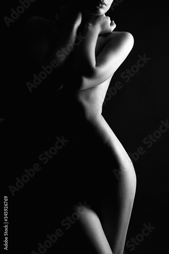 Obraz na płótnie Nude Woman silhouette under light in the dark w salonie