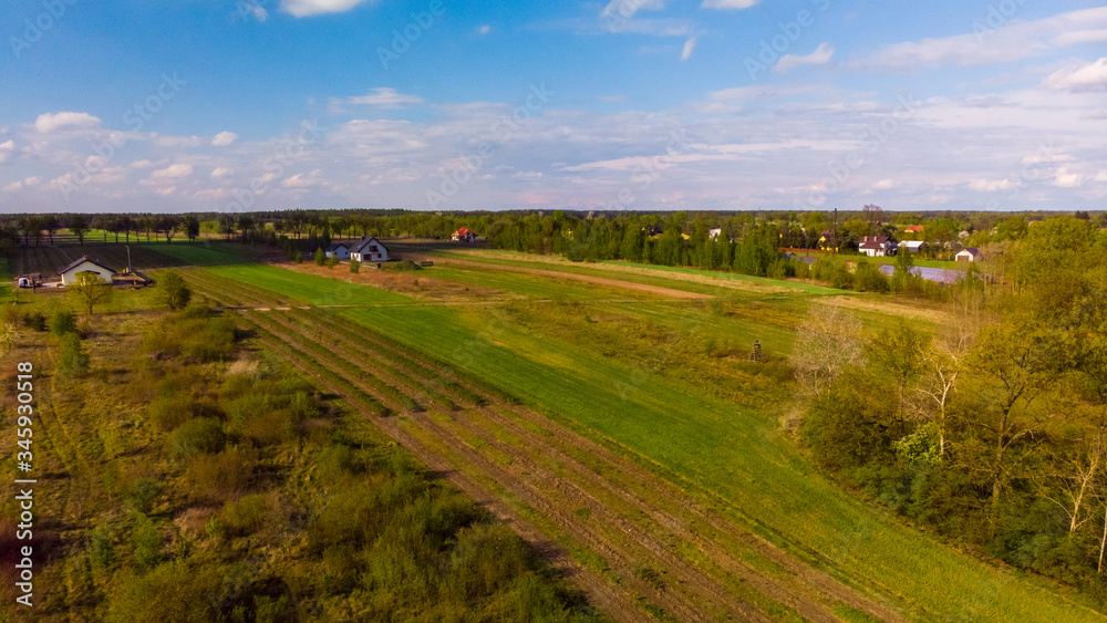 Shot from the drone on the green Polish agricultural fields