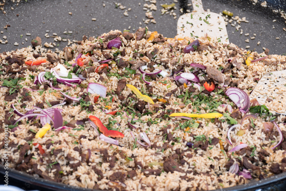 Obraz premium Seafood paella cooked in a large pan wok, street food festival. Mexican fiesta