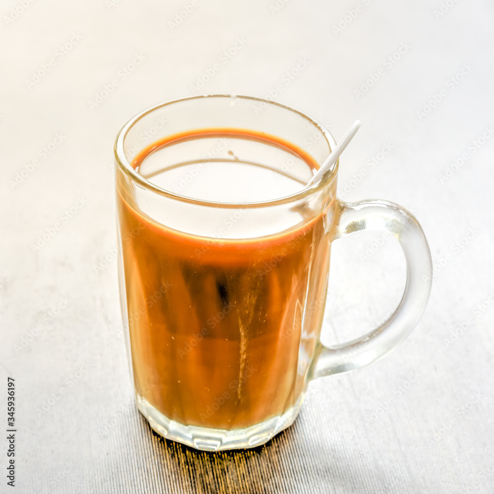 A cup of traditional Singaporean coffee cup with spoon of kopi made from Robusta beans A cup of traditional Singaporean coffee cup with spoon of kopi made from Robusta beans
