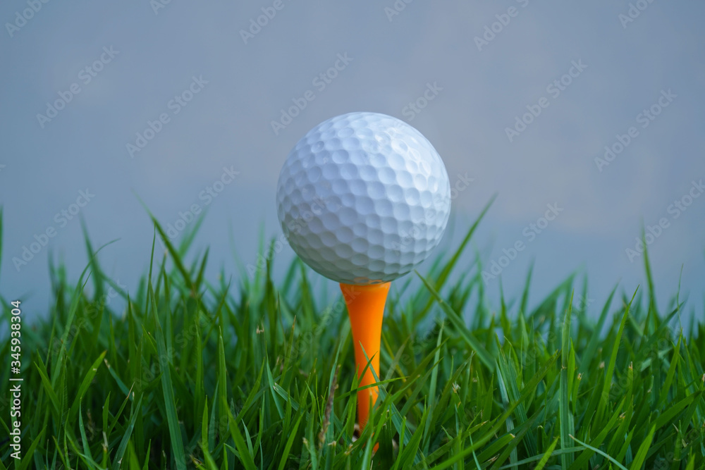 Golf ball on tee in the evening golf course with sunshine. Golf ball on tee in the evening golf course with sunshine.