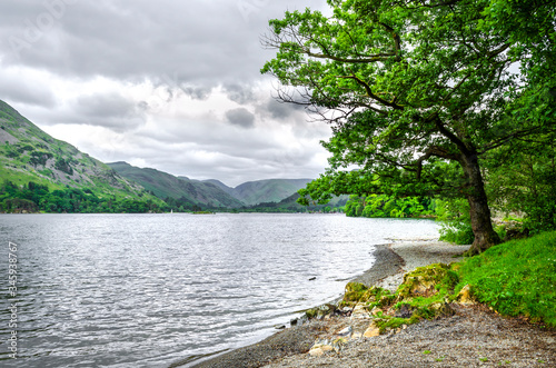 The bank of Ullswater in the Lake District showing the rambling hills and calm water. 