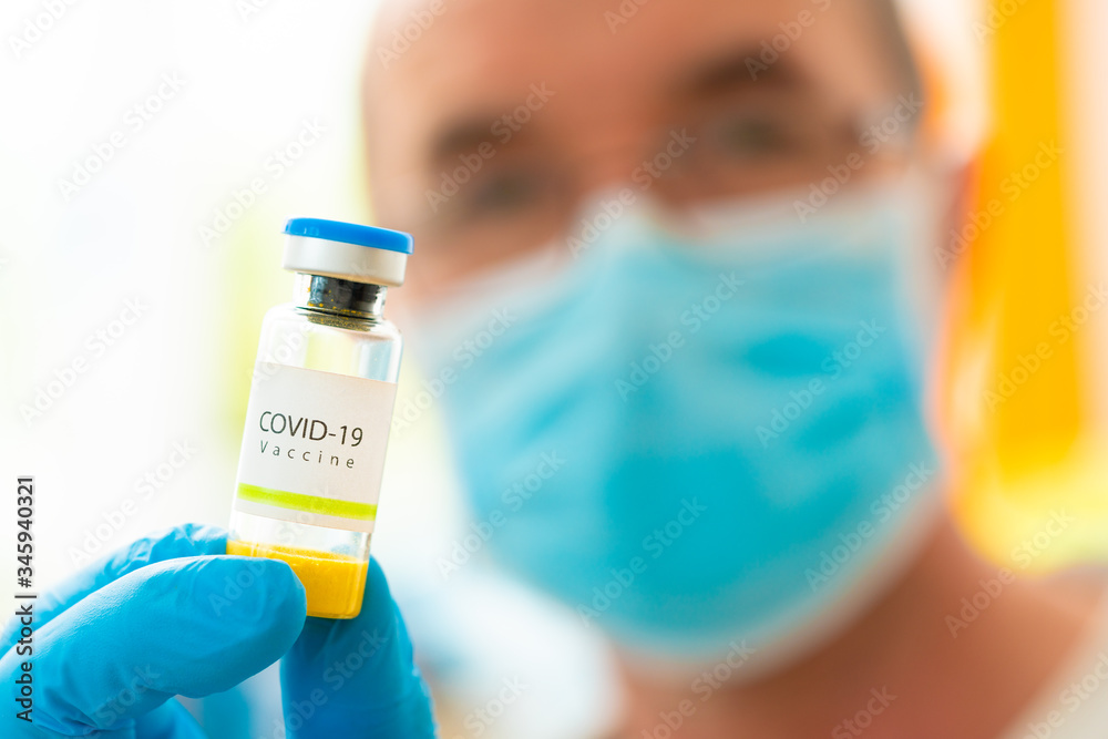 .Concept of doctor researcher with Vaccine for Covid-19 on a research laboratory. Doctor that holds in hands Vaccine vial for coronavirus prevention. .Concept of doctor researcher with Vaccine for Covid-19 on a research laboratory. Doctor that holds in hands Vaccine vial for coronavirus prevention.