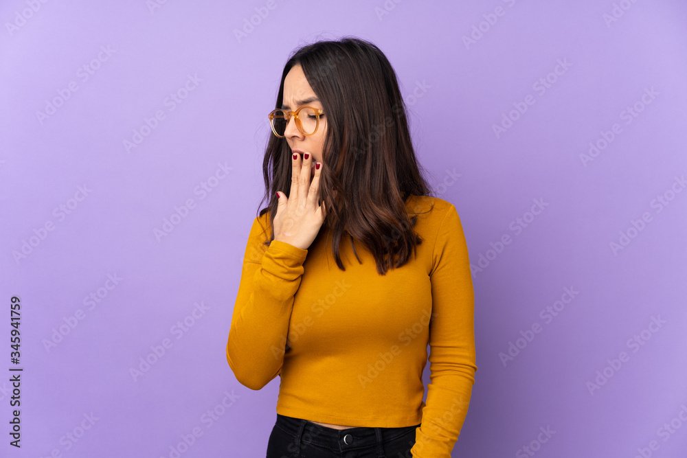 Young mixed race woman isolated on purple background yawning Young mixed race woman isolated on purple background yawning