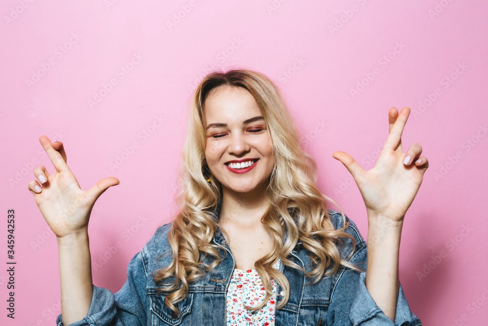 Image of a happy young blonde woman presenting love gestures and smiling over pink background Image of a happy young blonde woman presenting love gestures and smiling over pink background