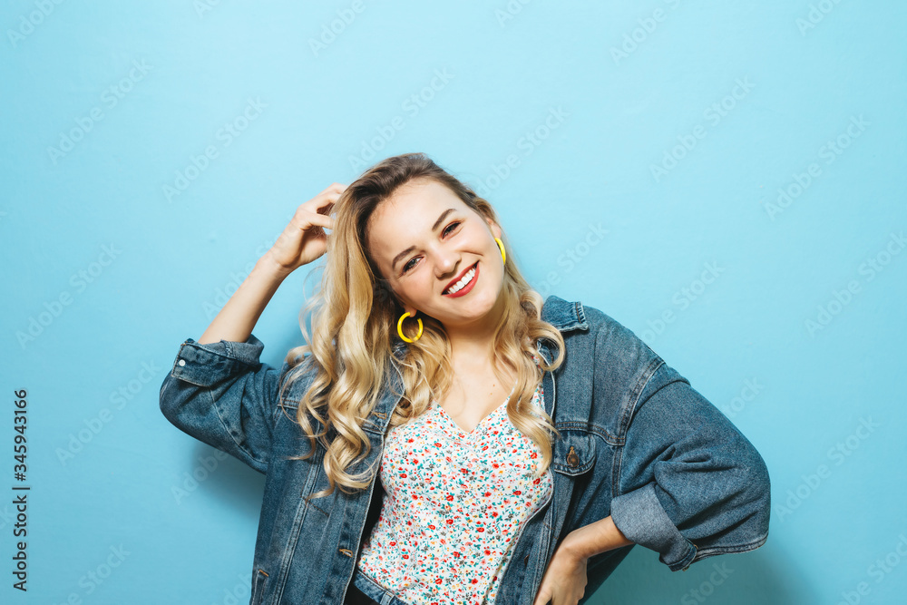 Portrait of a happy young woman presenting gestures and smiling over background