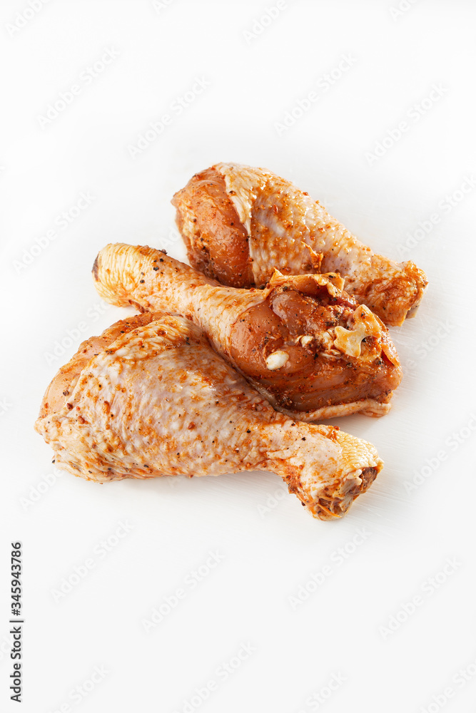 Raw drumsticks on white background. Chicken legs. Raw chicken marinated legs. Top view. Food Background. Cooking content. Uncooked meat. Meat shop concept.
